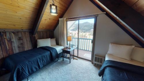 a attic bedroom with two beds and a window at Aspen Hollow In The Upper Valley With High Speed Wifi in Red River
