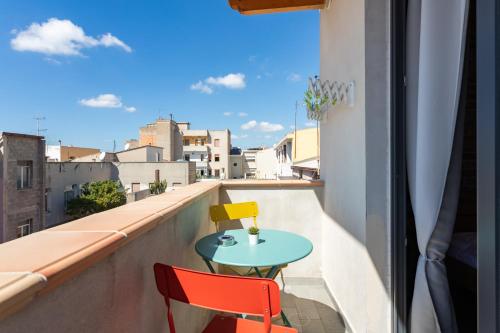 a table and two chairs on a balcony with a view at Old Rooms in Quartu SantʼElena