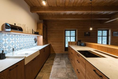 a large kitchen with wooden cabinets and a sink at Roubenky na Dupačce in Velké Karlovice