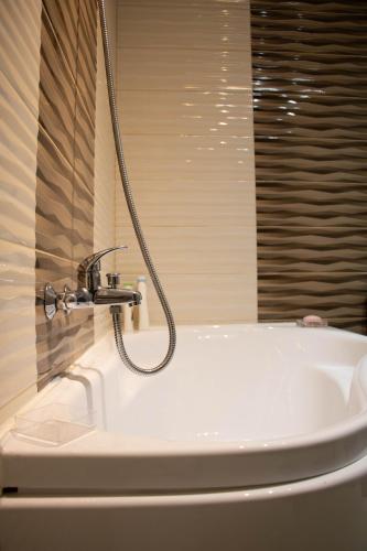a white bath tub with a faucet in a bathroom at Apartament Capitala Militari Rosu in Roşu