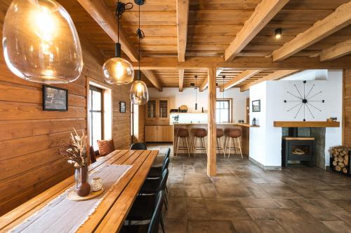 a dining room with a long wooden table and chairs at Roubenky na Dupačce in Velké Karlovice