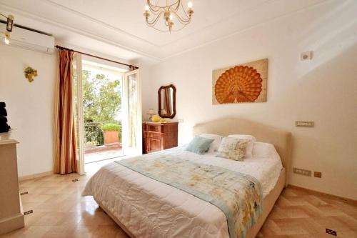 een slaapkamer met een bed en een groot raam bij CASA GADEAMUS via le botteghe 12 in Capri