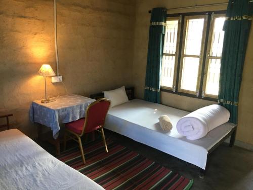 ein kleines Zimmer mit einem Bett und einem Tisch mit einer Lampe in der Unterkunft Mountain View Eco Farm in Rānīpauwa