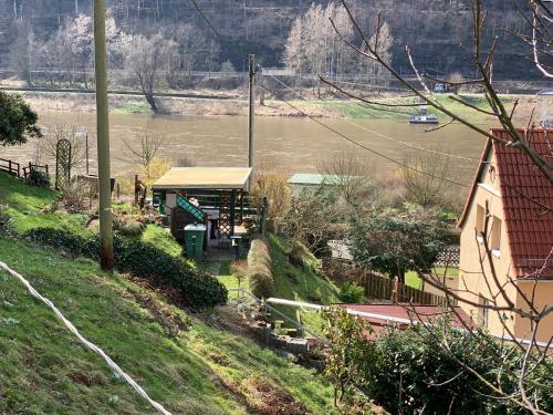 a building on a hill next to a river at Haus Bergfriede in Bad Schandau