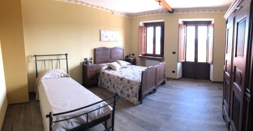 a bedroom with two beds and two windows at Cascina Coste in Roppolo