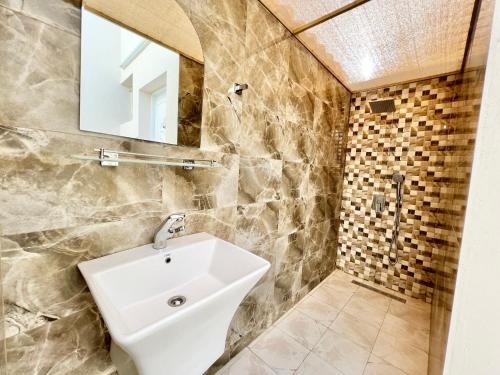 a bathroom with a sink and a mirror at AlDana Resort & Hotels in Barka