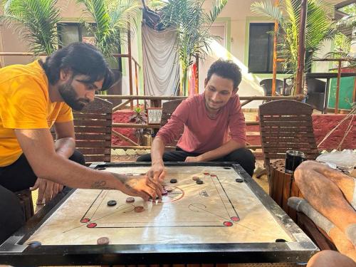 dos hombres jugando un juego en una mesa en Nature of Arambol en Arambol