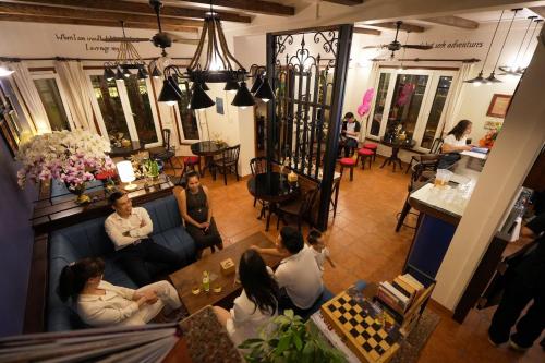 eine Gruppe von Menschen, die auf einer Couch in einem Zimmer sitzen in der Unterkunft Musketeers Guest House in Hanoi