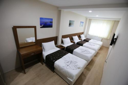 イスタンブールにあるIstanbul Family Apartmentのベッド3台と鏡が備わるホテルルーム
