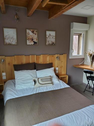 - une chambre avec un grand lit et une tête de lit en bois dans l'établissement camping hôtel les airelles, à Saint-Cirgues-en-Montagne