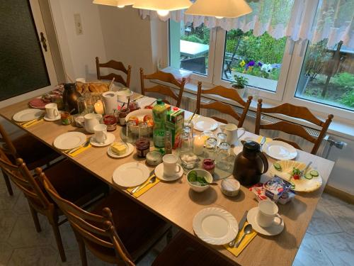 a dining room table with plates and bowls of food at Haus Bergfriede in Bad Schandau