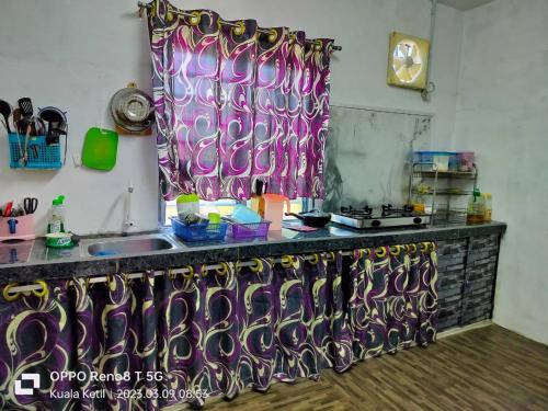 a kitchen with a counter with a sink and a window at Myrol Homestay Kuala Ketil in Kuala Ketil