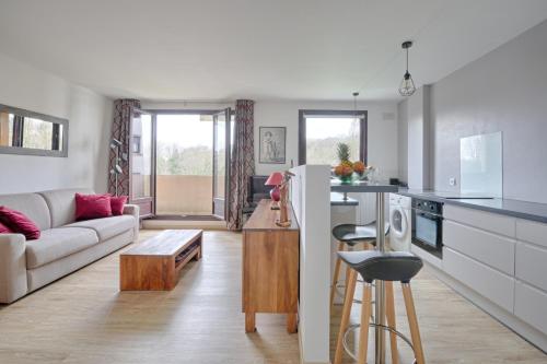une cuisine et un salon avec un canapé et une table dans l'établissement Swingcat - Charmant appt pour 2, à Athis-Mons