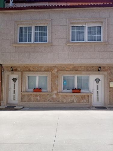 a building with three windows on the side of it at Casa Jesús in Muxia