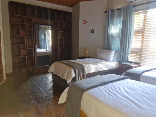 a hotel room with two beds and a window at Cobra Self-Catering Guesthouse in Citrusdal