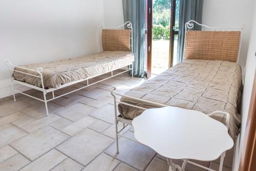two beds and a chair in a room at M347 - Marcelli, comodo trilocale nuovo con piscina e giardino in Santa Maria a Potenza