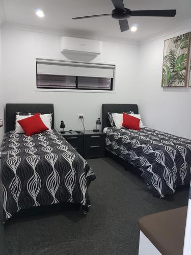 a bedroom with two beds with black and red pillows at Athena Studio Units in Roma