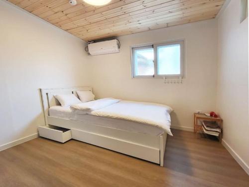 a bedroom with a bed in a room with a window at Sam House 2 Seochon in Seoul