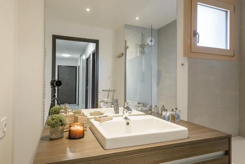La salle de bains est pourvue d'un lavabo blanc et d'un miroir. dans l'établissement ST JORIOZ centre - Appartement Lac et Semnoz 6pax, LLA Selections by Location lac Annecy, à Saint-Jorioz