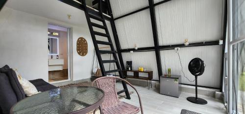 sala de estar con escalera y mesa de cristal en Pink house en San Lucas Tolimán