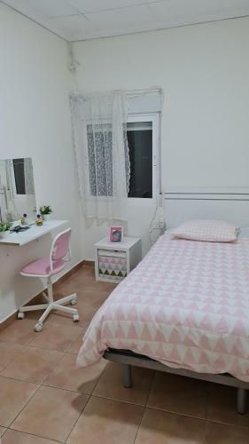 a bedroom with a bed and a desk and a chair at CASA HUERTA SOFIA in Murcia