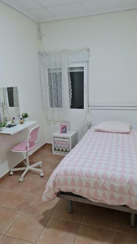 ein Schlafzimmer mit einem Bett, einem Schreibtisch und einem Stuhl in der Unterkunft CASA HUERTA SOFIA in Murcia