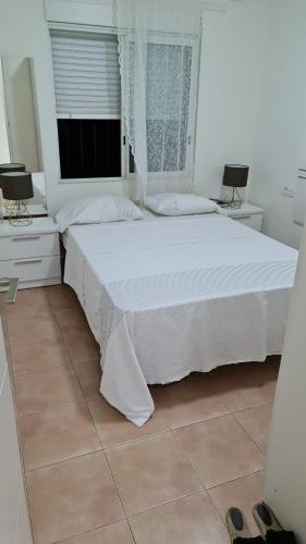 1 dormitorio con 1 cama blanca grande y ventana en CASA HUERTA SOFIA, en Murcia