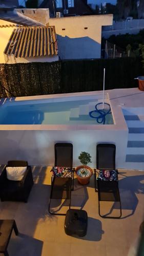 un par de sillas sentadas junto a una piscina en CASA HUERTA SOFIA, en Murcia