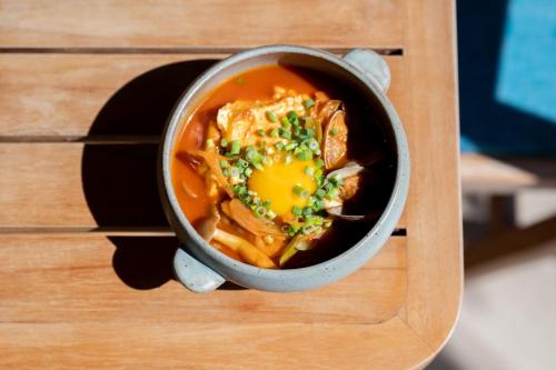 a bowl of soup on a wooden table at THIRD ishigakijima in Ishigaki Island