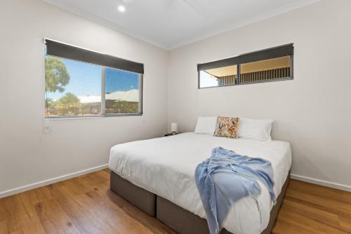 a white bedroom with a bed and a window at Dragonfly Abode, 2BR Villa in Cable Beach