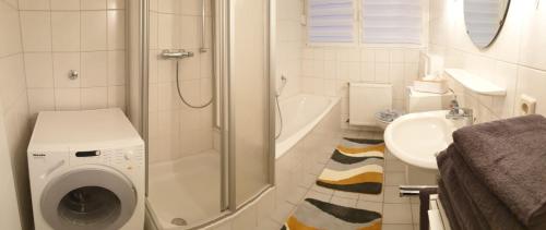 a bathroom with a washing machine and a sink at Ferienwohnung 24 Oben Rechts 4 Zimmer in Lathen