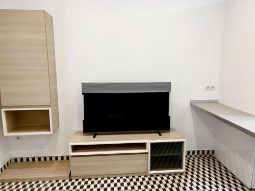 TV de pantalla plana sentada en un stand en una habitación en RockSide Residences Suites La Línea N1, en La Línea de la Concepción