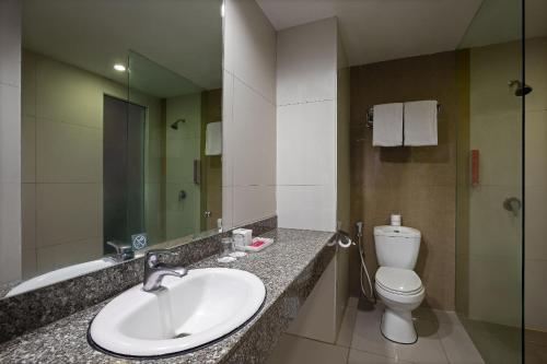 三寶壟的住宿－favehotel Simpang Lima - Semarang，一间带水槽、卫生间和镜子的浴室