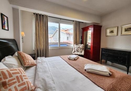 a bedroom with a large bed with two towels on it at Guney Suites by Villa Safiya in Göcek