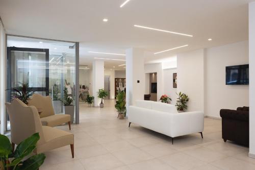 un vestíbulo de un hospital con un sofá blanco y sillas en Amiata Suite, en Abbadia San Salvatore