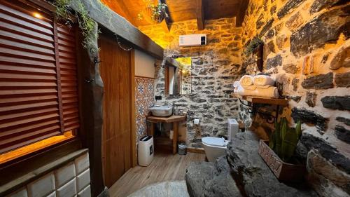 a stone bathroom with a toilet and a window at Haraneko errota Goiatzena in El Cerco