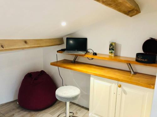Cette chambre comprend un bureau avec un ordinateur portable et un tabouret. dans l'établissement Le Refuge Ardéchois, à Pont-de-Labeaume