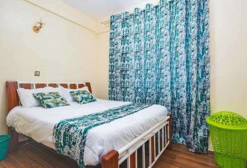 um quarto com uma cama com uma cortina azul em Tropical themed 3BR and DSQ Apartment em Nairobi
