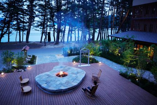 a patio with a fire pit and chairs on a deck at Hamabeno Ryouriyado Houraikan in Kamaishi