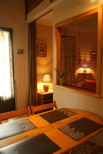 une salle à manger avec une table et une fenêtre dans l'établissement HAMEAU DU RIVAGE maison en Duplex en rez de jardin, residence avec piscine , proche plage, parking privatif, à Saint-Cyprien