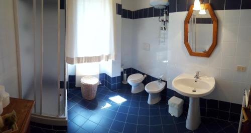 a blue tiled bathroom with a sink and a toilet at Terre Regionali Toscane in Alberese