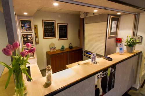 a reception counter with pink flowers in a vase at Ibis Budget Boulogne-Sur-Mer Centre les Ports in Boulogne-sur-Mer