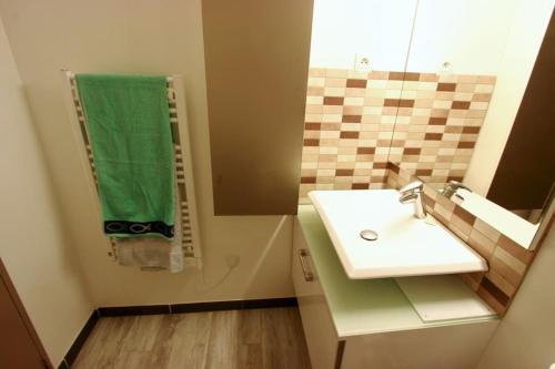 Un baño con un lavabo y una toalla verde. en Entre Port historique et Calanques, en La Ciotat