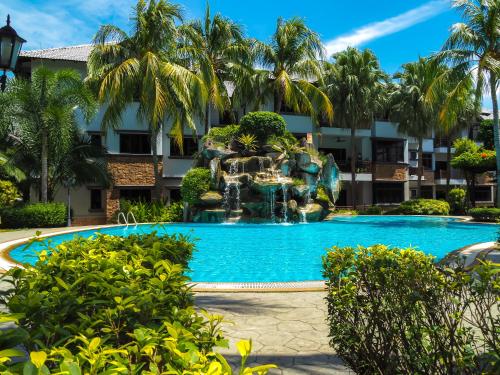 a swimming pool with a fountain in front of a building at Resort-styled Stay - No Pool, select 2 OR 3 bedrooms in Cyberjaya