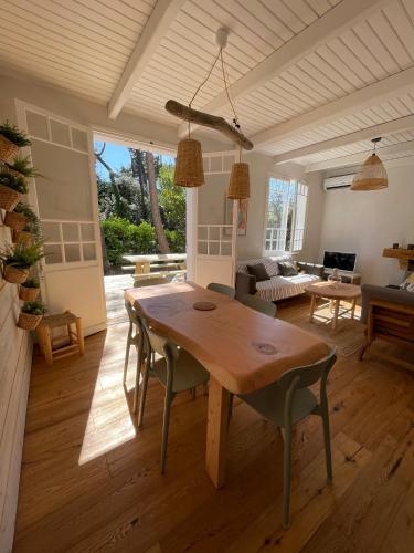 un salon avec une table et des chaises en bois dans l'établissement Villa Oraihola lacanau océan plage sud, à Lacanau