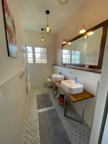 une salle de bain avec deux lavabos et un miroir dans l'établissement Villa Oraihola lacanau océan plage sud, à Lacanau