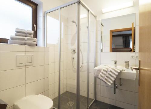 a bathroom with a shower and a toilet and a sink at Pension Anni in Wagrain