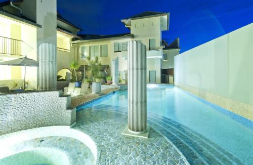 a villa with a swimming pool at night at Mantra in the Village in Port Douglas