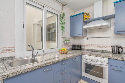 - une cuisine avec des placards bleus et un évier dans l'établissement Fuengirola apartment close to the beach Ref 06, à Torremolinos