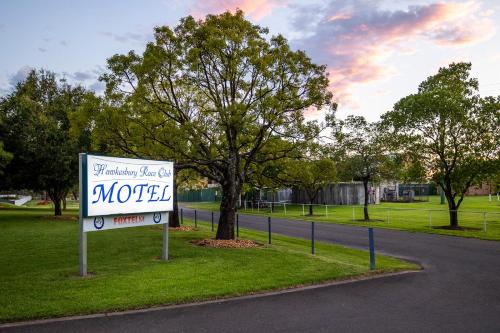 a sign for a motel on the side of a road at Hawkesbury Race Club Motel in Windsor